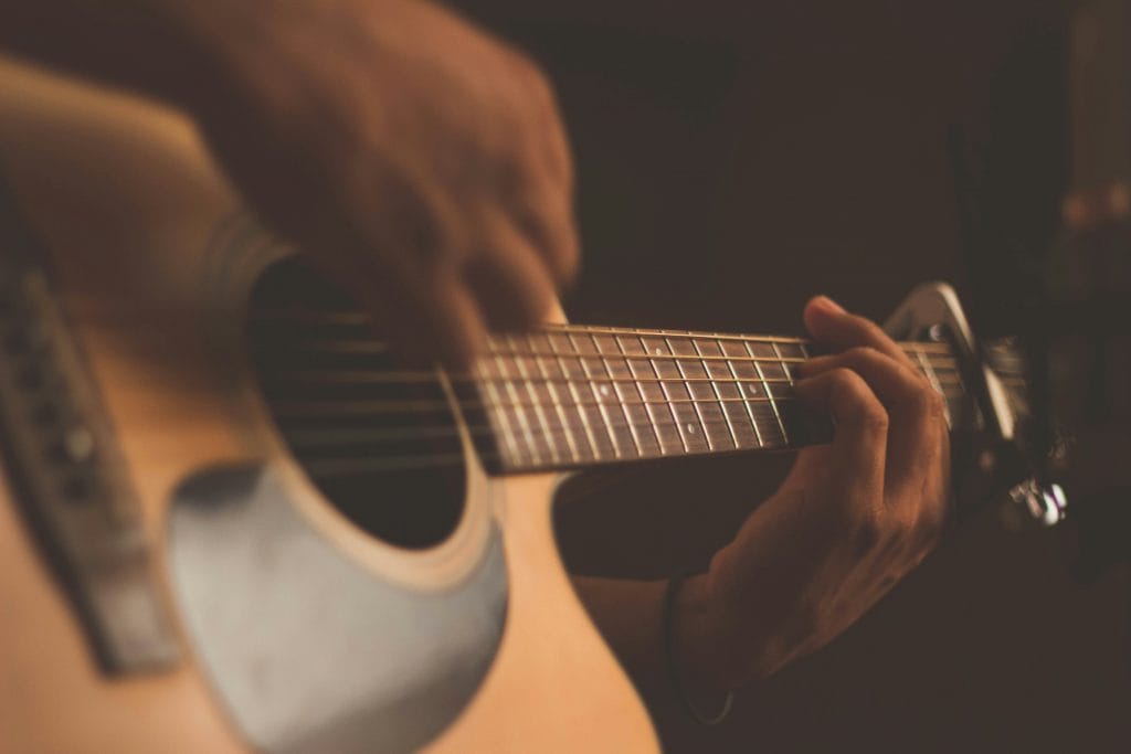 Hands playing a guitar